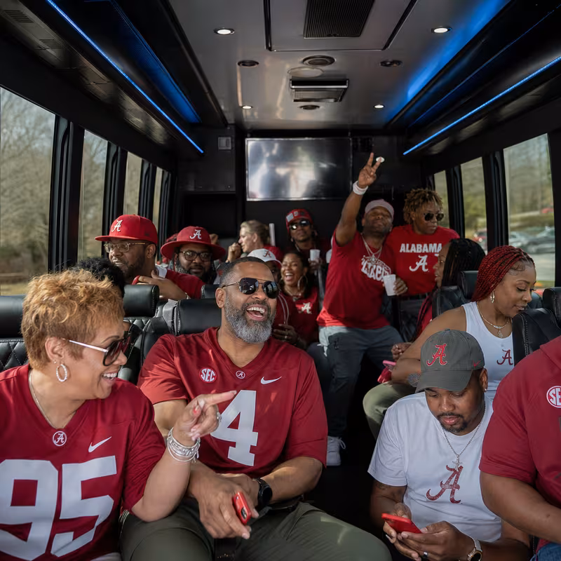 Group boarding a white charter bus for Sporting Event Transportation transportation in Arlington
