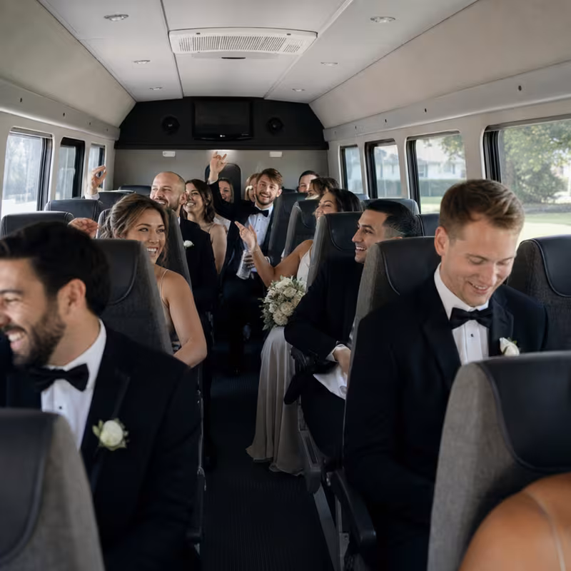 Group boarding a white charter bus for Wedding Transportation transportation in Arlington